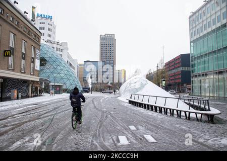 Sciogliendo la neve nel centro di Eindhoven in piazza 18 Septemberplein con un uomo in bicicletta. Il terzo giorno dell'insolita nevicata di aprile nei Paesi Bassi, il paese si risveglia sulla neve coperta dopo un'intensa nevicata mattutina, un evento bizzarro per aprile. Il 3rd° giorno di basse temperature e nevicate nei Paesi Bassi dopo il lunedì di 'Pasqua Bianca' con un significativo calo di temperatura, raggiungendo il punto di congelamento secondo l'agenzia meteorologica olandese KNMI rendendo il lunedì di Pasqua uno dei giorni più freddi mai registrati con basse temperature. Oltre alla neve, grandine e alta velocità forte ghiaccio-freddo Foto Stock