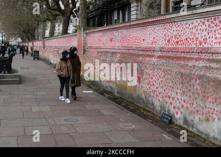 LONDRA, REGNO UNITO - 07 APRILE 2021: La gente passa davanti a un memoriale per le vittime di Covid-19 fuori dal St Thomas’ Hospital il 07 aprile 2021 a Londra, Inghilterra. Il murale, istituito da Covid-19 famiglie lotte per la giustizia lunedì scorso, ha visto finora circa 130.000 cuori disegnati a mano collocati su una sezione lunga un chilometro di muro di fronte alle Camere del Parlamento. (Foto di Wiktor Szymanowicz/NurPhoto) Foto Stock