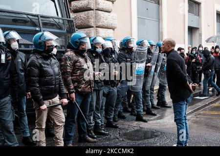 Un manifestante arangues una linea di agenti di polizia anti-tumulto durante una dimostrazione di proprietari di piccole imprese fase una protesta contro il governo Mario Draghi che chiede alle imprese di riaprire a Piazza San Silvestro vicino a Chigi a Roma, Italia il 12 aprile 2021. (Foto di Sirio Tesitore/NurPhoto) Foto Stock