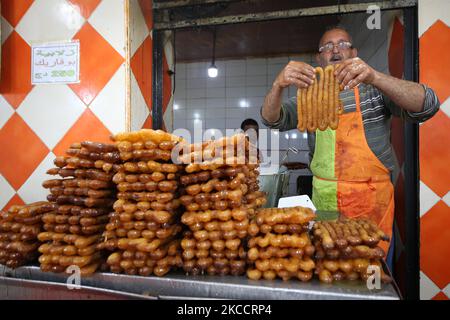 Un uomo algerino vende un dessert speciale conosciuto come 'zalabia' e succo di limone in una pasticceria a Boufarik, Algeria, 15 aprile 2021. Zalabiya è il dessert più popolare durante il mese santo del Ramadan in Algeria. Si mangia come dessert speciale. Dopo la prima colazione. I musulmani di tutto il mondo celebrano il mese benedetto del Ramadan pregando di notte e astenendosi dal mangiare e dal bere tra l'alba e il tramonto. Ramadan è il nono mese del calendario islamico. (Foto di Billal Bensalem/NurPhoto) Foto Stock