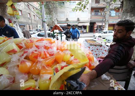 Un uomo algerino vende un dessert speciale conosciuto come 'zalabia' e succo di limone in una pasticceria a Boufarik, Algeria, 15 aprile 2021. Zalabiya è il dessert più popolare durante il mese santo del Ramadan in Algeria. Si mangia come dessert speciale. Dopo la prima colazione. I musulmani di tutto il mondo celebrano il mese benedetto del Ramadan pregando di notte e astenendosi dal mangiare e dal bere tra l'alba e il tramonto. Ramadan è il nono mese del calendario islamico. (Foto di Billal Bensalem/NurPhoto) Foto Stock