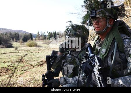 I soldati dell'esercito degli Stati Uniti trasmettono le informazioni mentre conducono la ricognizione della zona. Foto Stock