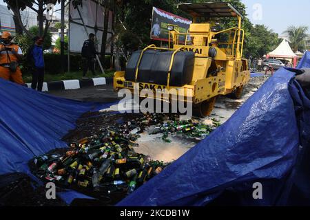 Il governo della regione orientale di Giacarta ha distrutto le bevande alcoliche, con varie marche sulla base del settore Pulogadung Ufficio di polizia a Giacarta, Indonesia il 23 aprile 2021. Migliaia di bottiglie di alcol di varie marche sono state distrutte per essere state schiacciate da attrezzature pesanti. Le bevande sono state ottenute da un'operazione congiunta delle autorità durante i due mesi in cui stavano subendo incursioni che hanno causato perdite sociali alla comunità.(Foto di Dasril Roszandi/NurPhoto) Foto Stock