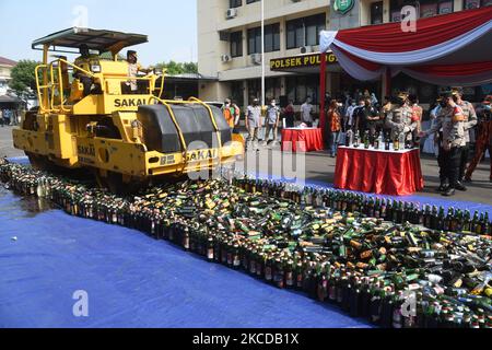 Il governo della regione orientale di Giacarta ha distrutto le bevande alcoliche, con varie marche sulla base del settore Pulogadung Ufficio di polizia a Giacarta, Indonesia il 23 aprile 2021. Migliaia di bottiglie di alcol di varie marche sono state distrutte per essere state schiacciate da attrezzature pesanti. Le bevande sono state ottenute da un'operazione congiunta delle autorità durante i due mesi in cui stavano subendo incursioni che hanno causato perdite sociali alla comunità.(Foto di Dasril Roszandi/NurPhoto) Foto Stock