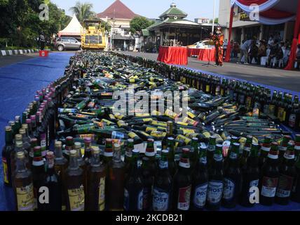 Il governo della regione orientale di Giacarta ha distrutto le bevande alcoliche, con varie marche sulla base del settore Pulogadung Ufficio di polizia a Giacarta, Indonesia il 23 aprile 2021. Migliaia di bottiglie di alcol di varie marche sono state distrutte per essere state schiacciate da attrezzature pesanti. Le bevande sono state ottenute da un'operazione congiunta delle autorità durante i due mesi in cui stavano subendo incursioni che hanno causato perdite sociali alla comunità.(Foto di Dasril Roszandi/NurPhoto) Foto Stock