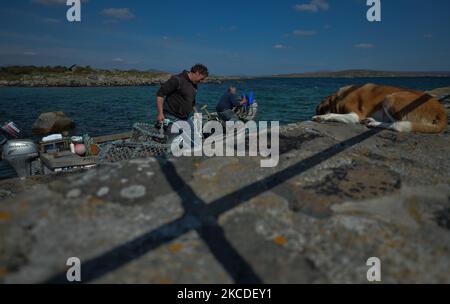 Il pescatore locale Michael John (a sinistra) e il suo vicino Brendan Devane, nella foto del porto di Ervallagh vicino a Roundstone, preparano una barca da pesca per un viaggio di pesca. Domenica 25 aprile 2021, a Ervallagh, Roundstone, Connemara, Galway, Irlanda. (Foto di Artur Widak/NurPhoto) Foto Stock
