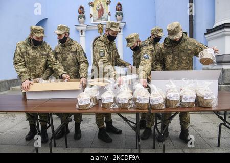 Uomini di servizio ucraini durante la cerimonia o santificare il tradizionale pasquale di pane ucraino di fronte alla cattedrale di San Michele a Kyiv, Ucraina, il 26 aprile 2021, che sarà inviato ai soldati ucraini coinvolti nell'operazione delle forze congiunte nella parte orientale dell'Ucraina, Avanti di Pasqua.(Foto di Maxym Marusenko/NurPhoto) Foto Stock