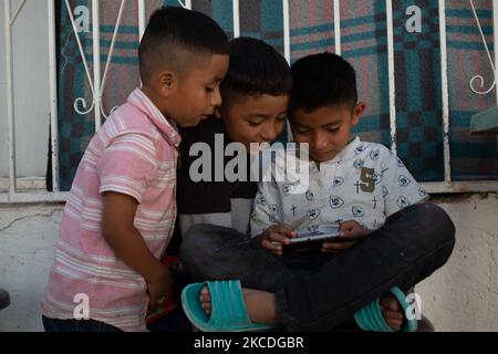 I bambini migranti giocano nel cortile del rifugio di Ciudad Juarez Chihuahua, Messico, il 26 aprile 2021. Centinaia di uomini e donne accompagnati dai loro figli vengono deportati ogni giorno dal ponte internazionale Paso del Norte a Ciudad Juarez e portati nei rifugi della città in attesa della richiesta di asilo politico negli Stati Uniti. (Foto di David Peinado/NurPhoto) Foto Stock