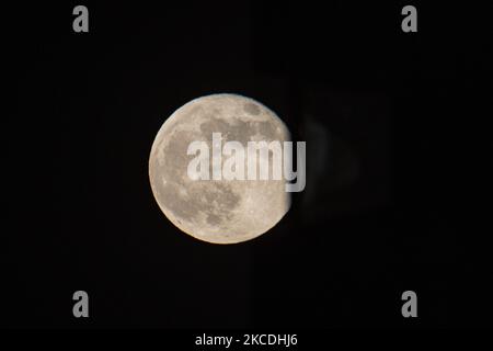 La Luna piena o la Superluna Rosa o la Luna Super Rosa del 2021 aprile, come si vede dalla città olandese, Eindhoven, Paesi Bassi il 27 aprile 2021, che si erge sopra l'orizzonte dietro gli edifici di colore rosso. La luna piena super è più grande e più luminosa nel cielo perché è più vicina alla Terra., 14 per cento più grande e 30 per cento più luminoso di una dimensione e luminosità comuni di una luna normale. Il nome della Luna Rosa è legato alla fioritura primaverile dei fiori. Altri nomi il satellite naturale della Terra in orbita attorno al pianeta e il satellite più grande del sistema solare sono Selene, Luna e Cynthia. (Pho Foto Stock