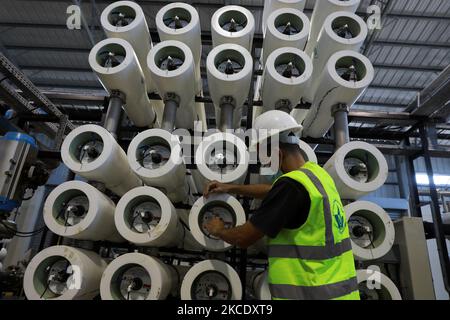 Un ingegnere palestinese lavora in un impianto per convertire l'acqua di mare in acqua dolce a Gaza City il 3 maggio 2021. (Foto di Majdi Fathi/NurPhoto) Foto Stock