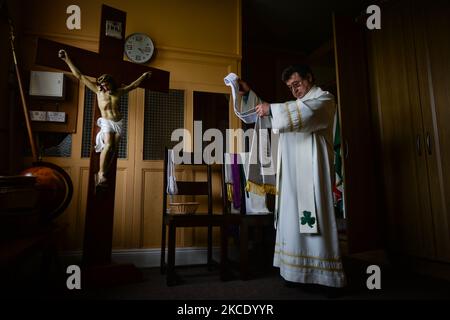 Padre Krzysztof Sikora si prepara alla preghiera privata presso la chiesa cattolica "nostra Signora Stella del Mare" di Roundstone. A causa delle restrizioni del Covid-19, tutte le cerimonie religiose sono ancora annullate. Geograficamente, la parrocchia di Roundstone è considerata la più grande parrocchia d'Irlanda e si estende dalle spiagge di Gurteen ai Monti Twelve Bens e Mám Tuirc. Fino agli anni '1990s la parrocchia era servita da tre sacerdoti, ora CE n'è una sola che si occupa di cinque chiese. L'attuale Parroco, padre Krzysztof Sikora, nato in Polonia, è membro della congregazione religiosa del Verbo Divino Foto Stock