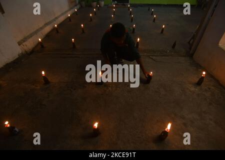 I musulmani etnici di Gorontalo realizzano la tradizione Tumbilotohe o luci notturne nel loro cortile a Palu, nella Provincia Centrale di Sulawesi, Indonesia, il 9 maggio 2021. La tradizione di accendere un fuoco su una bottiglia con uno stoppino attaccato ad essa è una tradizione tipica della comunità etnica musulmana di Gorontalo che si svolge per accogliere la celebrazione di Eid al-Fitr. (Foto di Mohamad Hamzah/NurPhoto) Foto Stock