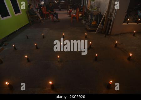 I musulmani etnici di Gorontalo realizzano la tradizione Tumbilotohe o luci notturne nel loro cortile a Palu, nella Provincia Centrale di Sulawesi, Indonesia, il 9 maggio 2021. La tradizione di accendere un fuoco su una bottiglia con uno stoppino attaccato ad essa è una tradizione tipica della comunità etnica musulmana di Gorontalo che si svolge per accogliere la celebrazione di Eid al-Fitr. (Foto di Mohamad Hamzah/NurPhoto) Foto Stock