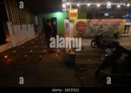 I musulmani etnici di Gorontalo realizzano la tradizione Tumbilotohe o luci notturne nel loro cortile a Palu, nella Provincia Centrale di Sulawesi, Indonesia, il 9 maggio 2021. La tradizione di accendere un fuoco su una bottiglia con uno stoppino attaccato ad essa è una tradizione tipica della comunità etnica musulmana di Gorontalo che si svolge per accogliere la celebrazione di Eid al-Fitr. (Foto di Mohamad Hamzah/NurPhoto) Foto Stock