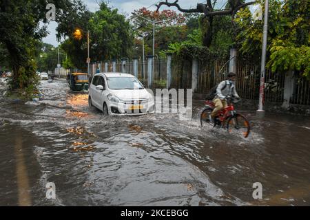 Diversi veicoli cercano di percorrere una strada allagata dopo una forte pioggia di monsoni a Kolkata , in India , il 11 maggio 2021 . (Foto di Debarchan Chatterjee/NurPhoto) Foto Stock