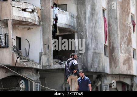 I palestinesi ispezionano i danni in un edificio residenziale dopo che è stato colpito dagli attacchi aerei israeliani in mezzo all'escalation della violenza israelo-palestinese il 12 maggio 2021 nella città di Gaza. Il Ministero della Salute nella striscia di Gaza, gestita da Hamas, ha dichiarato che il numero di palestinesi uccisi è salito a 35, di cui 12 bambini, mentre 233 persone sono state segnalate ferite.(Foto di Momen Faiz/NurPhoto) Foto Stock