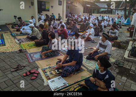 I musulmani indonesiani indossano maschere protettive che si riuniscono per eseguire la preghiera di Eid al-Fitr a Yogyakarta, Indonesia, il 13 maggio 2021. I musulmani di tutto il mondo celebrano Eid al-Fitr che segna la fine del Ramadan tra le preoccupazioni della pandemia di coronavirus COVID-19. (Foto di Rizqullah Hamiid/NurPhoto) Foto Stock