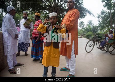 Una famiglia musulmana sta aspettando fuori perché non ha avuto il posto per pregare nella moschea il 14 maggio 2021 a Bogra in Bangladesh (Foto di Masfiqur Sohan/NurPhoto) Foto Stock