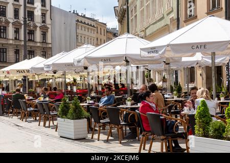 Gli ospiti potranno gustare bevande e cibo nella piazza del mercato principale di Cracovia, mentre il governo polacco rilassa lentamente le restrizioni di Coronavirus, poiché il numero di casi diminuisce significativamente nella città vecchia di Cracovia, in Polonia, il 15 maggio 2021. Il blocco del coronavirus è in parte rimosso dal momento che la Polonia è riuscita a vaccinare circa 15 milioni di persone e il numero di casi di Covid è basso. Pub e ristoranti possono ora ospitare gli ospiti all'aperto e la gente non ha bisogno di indossare maschere facciali. (Foto di Dominika Zarzycka/NurPhoto) Foto Stock