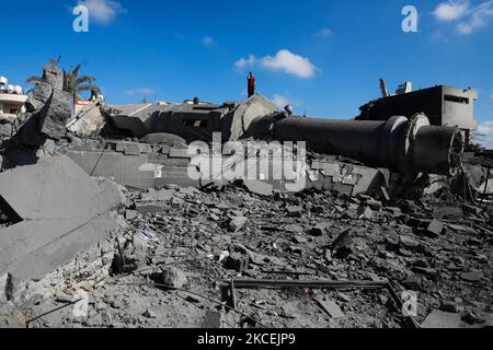 Un muezzin palestinese invita alla preghiera sulle macerie della moschea Abdul Razzaq Qlebo nel campo profughi di Jabalia nella striscia di Gaza settentrionale dopo il bombardamento aereo israeliano all'inizio del 15 maggio 2021. – I jet da combattimento israeliani hanno picchiato la striscia di Gaza durante la notte, uccidendo 10 membri di una sola famiglia, i medici hanno detto, dopo una giornata di violenza mortale ha fatto oscillare la Cisgiordania e un inviato degli Stati Uniti è arrivato per i colloqui. (Foto di Majdi Fathi/NurPhoto) Foto Stock