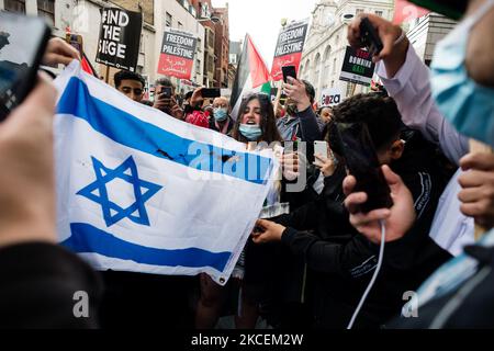 I sostenitori della Palestina bruciano la bandiera israeliana durante una manifestazione all'esterno dell'Ambasciata israeliana a Londra, Gran Bretagna, 15 maggio 2021. Il raduno si è svolto per protestare contro le incursioni aeree israeliane a Gaza, lo spiegamento delle forze israeliane contro i fedeli alla moschea al-Aqsa durante il Ramadan e i tentativi di spostare con la forza le famiglie palestinesi dal quartiere Sheikh Jarrah di Gerusalemme est. (Foto di Maciek Musialek/NurPhoto) Foto Stock