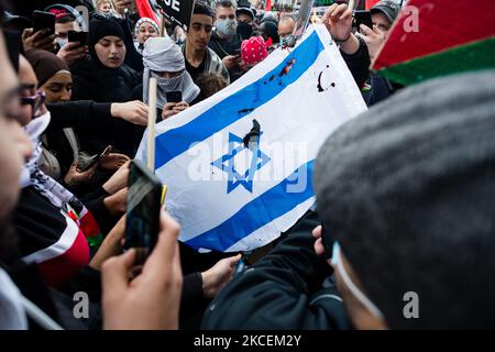 I sostenitori della Palestina bruciano la bandiera israeliana durante una manifestazione all'esterno dell'Ambasciata israeliana a Londra, Gran Bretagna, 15 maggio 2021. Il raduno si è svolto per protestare contro le incursioni aeree israeliane a Gaza, lo spiegamento delle forze israeliane contro i fedeli alla moschea al-Aqsa durante il Ramadan e i tentativi di spostare con la forza le famiglie palestinesi dal quartiere Sheikh Jarrah di Gerusalemme est. (Foto di Maciek Musialek/NurPhoto) Foto Stock