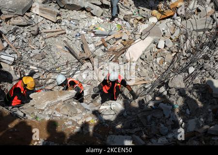 I paramedici palestinesi cercano i sopravvissuti sotto le macerie di un edificio distrutto a Gaza City il 16 maggio 2021, a seguito del massiccio bombardamento israeliano dell'enclave controllata da Hamas. – L’esercito israeliano ha dichiarato di aver bombardato la casa del leader politico del gruppo islamico Hamas nella striscia di Gaza, mentre il Consiglio di sicurezza delle Nazioni Unite si riuniva sotto l’allarme globale sull’intensificarsi del conflitto. (Foto di Majdi Fathi/NurPhoto) Foto Stock