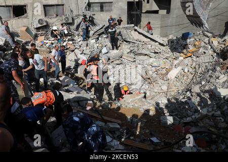 I paramedici palestinesi cercano i sopravvissuti sotto le macerie di un edificio distrutto a Gaza City il 16 maggio 2021, a seguito del massiccio bombardamento israeliano dell'enclave controllata da Hamas. – L’esercito israeliano ha dichiarato di aver bombardato la casa del leader politico del gruppo islamico Hamas nella striscia di Gaza, mentre il Consiglio di sicurezza delle Nazioni Unite si riuniva sotto l’allarme globale sull’intensificarsi del conflitto. (Foto di Majdi Fathi/NurPhoto) Foto Stock