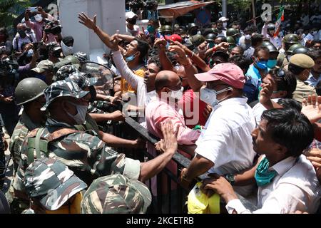 Il personale paramilitare è in guardia all'ingresso dell'ufficio dell'Ufficio Centrale d'inchiesta (CBI), mentre i sostenitori del Trinamool Congress (TMC) gridano slogan dopo che il CBI ha arrestato quattro leader del Trinamool Congress (TMC) in relazione al caso dell'operazione di sting Narada del 2016, a Kolkata il 17 maggio 2021. (Foto di Debajyoti Chakraborty/NurPhoto) Foto Stock