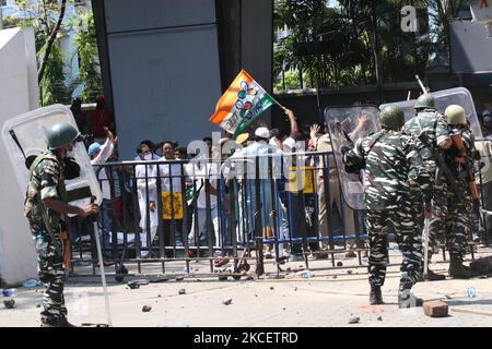 Il personale paramilitare è in guardia all'ingresso dell'ufficio dell'Ufficio Centrale d'inchiesta (CBI), mentre i sostenitori del Trinamool Congress (TMC) gridano slogan dopo che il CBI ha arrestato quattro leader del Trinamool Congress (TMC) in relazione al caso dell'operazione di sting Narada del 2016, a Kolkata il 17 maggio 2021. (Foto di Debajyoti Chakraborty/NurPhoto) Foto Stock