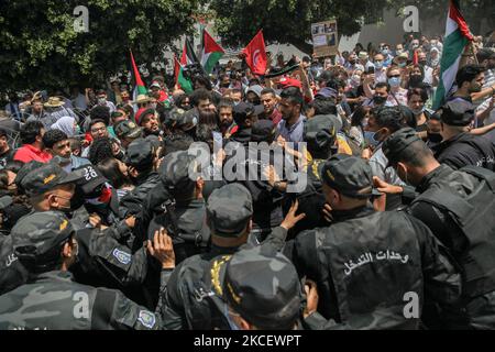 I manifestanti si scontrano con le forze di sicurezza che hanno impedito loro di avvicinarsi alla porta dell'edificio del parlamento tunisino nella città di Bardo Tunisi, in Tunisia, il 18 maggio 2021, durante una manifestazione che chiede l'adozione di una legge da parte del parlamento, Ciò criminalizza tutte le forme di normalizzazione delle relazioni con Israele. I dimostranti hanno protestato anche contro gli attacchi aerei israeliani sulla striscia di Gaza e contro le violazioni israeliane nei territori occupati in Palestina, in particolare nel quartiere palestinese Sheikh Jarrah a Gerusalemme est. La protesta arriva dopo più di una settimana di violo Foto Stock