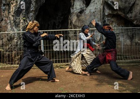 Gli studenti dell'eremo del Pencak silat mostrano le loro azioni durante la processione di Puhun Pusaka Karatuan il 19 maggio 2021 a Goa Pawon, Gunung Masigit, West Bandung Regency, Indonesia. 'Puhun Pusaka Karatuan' è un processo di richiesta di benedizioni dagli antenati così come la processione per la consegna di armi (heirlooms) ai loro discendenti. Secondo l'anziano di Goa Pawon o Grotta di Pawon in inglese, H. Elan Sumarna, in tempi antichi Goa Pawon fu utilizzato come luogo di pellegrinaggio per i guerrieri di Pencak silat. Per padroneggiare la scienza del silato di Pencak i discendenti dei precedenti antenati devono essere addestrati t Foto Stock