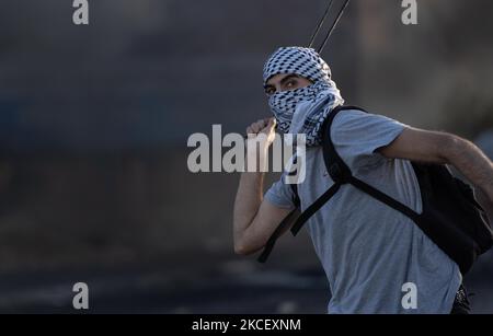 Un manifestante palestinese usa un tiro a schiaffo per lanciare pietre contro i soldati israeliani durante gli scontri nei pressi dell'insediamento ebraico di Beit El vicino a Ramallah nella Cisgiordania occupata il 18 maggio 2021. (Foto di Ahmad Talat/NurPhoto) Foto Stock