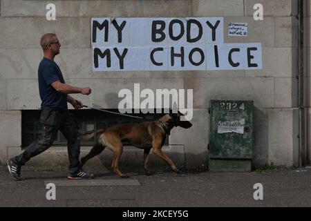 Un uomo con un cane cammina con gli adesivi "My Body My Choice" visti su un muro nel centro di Belfast. Mercoledì 19 maggio 2021 a Belfast, Irlanda del Nord (Foto di Artur Widak/NurPhoto) Foto Stock