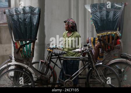 Un estrattore di risciò attende il passeggero in mezzo al blocco a Dhaka, Bangladesh, il 18 maggio 2021. (Foto di Syed Mahamudur Rahman/NurPhoto) Foto Stock