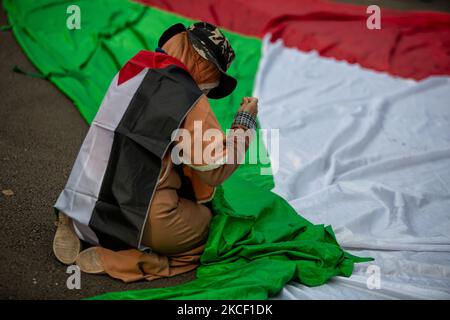 Donne indonesiane che cucono la bandiera palestinese al di fuori dell'ambasciata degli Stati Uniti a Giacarta, Indonesia il 21 maggio 2021. Centinaia di manifestanti hanno organizzato un raduno al di fuori dell'ambasciata degli Stati Uniti a Giacarta in solidarietà con il popolo palestinese a seguito di violenti scontri tra le forze di sicurezza israeliane e i palestinesi, esortando Israele a fermare gli attacchi a Gaza, in cui sono stati uccisi anche donne e bambini. (Foto di Afriadi Hikmal/NurPhoto) Foto Stock