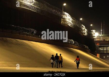 I migranti camminano lungo il Muro di frontiera degli Stati Uniti dopo aver attraversato Rio Bravo dal Messico agli Stati Uniti il 21 maggio 2021 a Ciudad Juarez Messico. I migranti con figli attraversano Rio Bravo dal Messico agli Stati Uniti il 21 maggio 2021 a Ciudad Juarez Messico. Secondo stime non ufficiali circa 200.000 migranti hanno attraversato gli Stati Uniti lungo il confine meridionale dal febbraio 2021. (Foto di John Lamparski/NurPhoto) Foto Stock