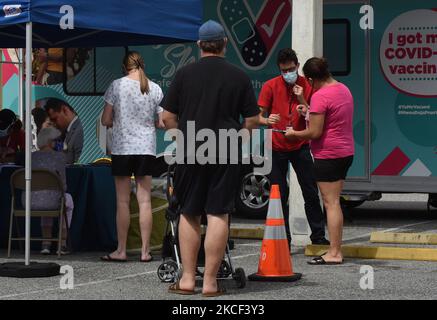 Le persone si registrano per ricevere un vaccino Pfizer COVID-19 in un sito di vaccinazione mobile presso la Oak Ridge High School il 22 maggio 2021 a Orlando, Florida. Il dipartimento sanitario della contea di Orange ha chiuso ieri il suo sito di vaccinazione di massa presso il Centro Congressi della contea di Orange, mentre si sposta verso siti mobili più piccoli con una nuova attenzione alla vaccinazione degli adolescenti. (Foto di Paul Hennessy/NurPhoto) Foto Stock