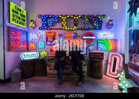 LONDRA, REGNO UNITO - 25 MAGGIO 2021: I neon maker e designer Linda e Marcus Bracey (L-R) di Gods Own Junkyard posano accanto a un'installazione caratterizzata da insegne e neon di film hollywoodiani creati da Chris Bracey durante un invito fotografico per la mostra 'Electric City' al Leadenhall Market, il 25 maggio 2021 a Londra, Inghilterra. La collaborazione di Gods Own Junkyard's e Leadenhall Market 'Electric City' (26th maggio – sabato 31st luglio 2021) è una coinvolgente mostra di neon e set-pieces realizzati per il film, tra cui le opere di insegne di Stanley Kubrick's Eyes Wide Shut, Judge Dredd, Batman, T. Foto Stock