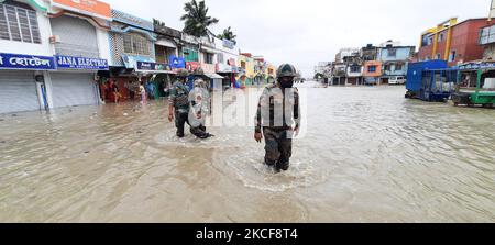 Il Jawan dell'esercito indiano cammina sotto l'acqua andando al posto effattato al salvataggio mentre l'acqua di mare raggiunge una strada vicina mentre il Cyclone Yaas barrilla verso la costa orientale dell'India nella baia del Bengala, in Doha, India il 26 maggio 2021. (Foto di Debajyoti Chakraborty/NurPhoto) Foto Stock