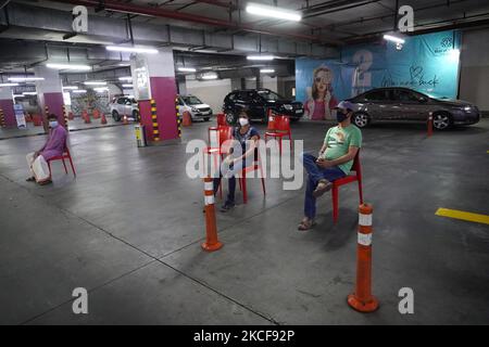 La gente attende in un'area di osservazione dopo aver ricevuto una dose di vaccino Covid-19 in un sito di vaccinazione drive-through istituito presso il centro commerciale DLF dell'India a Noida, Utttar Pradesh, India il 26 maggio 2021. Secondo il Ministero della Salute dell’Unione, l’India è diventata il secondo paese dopo che gli Stati Uniti hanno superato la copertura vaccinale cumulativa COVID-19 di 20 crore. (Foto di Mayank Makhija/NurPhoto) Foto Stock