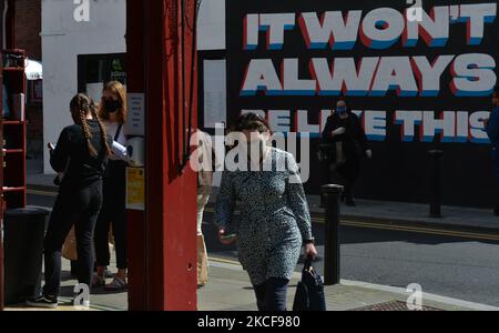 La gente cammina per un murale con le parole 'NON SARÀ SEMPRE COME QUESTO', dell'artista irlandese Emmalene Blake/ESTR, visto nel centro di Dublino. Mercoledì 26 maggio 2021, a Dublino, Irlanda. (Foto di Artur Widak/NurPhoto) Foto Stock