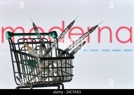 Le siringhe mediche nel mini carrello sono visibili davanti al logo di moderna visualizzato su uno schermo. Venerdì 28 maggio 2021 a Dublino, Irlanda. (Foto di Artur Widak/NurPhoto) Foto Stock