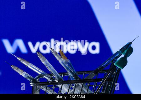 Le siringhe mediche nel mini carrello sono visibili davanti al logo Valneva visualizzato su uno schermo. Venerdì 28 maggio 2021 a Dublino, Irlanda. (Foto di Artur Widak/NurPhoto) Foto Stock