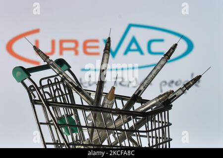 Le siringhe mediche nel mini carrello sono visibili davanti al logo CureVac visualizzato su uno schermo. Venerdì 28 maggio 2021 a Dublino, Irlanda. (Foto di Artur Widak/NurPhoto) Foto Stock