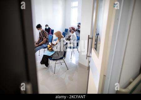 Sig.ra SRI INTAN (75 anni) (a metà destra) parlando con un altro ricevente del vaccino durante dopo l'osservazione del vaccino per assicurarsi che tutto sia ok. Vaccinazione Covid19 per gli anziani presso la Public Health Facility Ciater Permai, South Tangerang, Banten, Indonesia il 28 maggio 2021. Copertura la vaccinazione per gli anziani in Indonesia già raggiunge il 11% che ancora lontano dal target del 100%, gli anziani sono le più vittime di morte per pandemia da virus corona in Indonesia. (Foto di Donal Husni/NurPhoto) Foto Stock