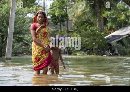 La gente del villaggio sta cercando di attraversare il sentiero che è sommerso in acqua allagata come argini del fiume hanno rotto e diversi villaggi allagati. Il 28 maggio 2021 a Sud 24 Parganas, Bengala Occidentale, India. Le persone nel Bengala occidentale sono pesantemente colpite dal fatto che gli argini del fiume si sono rotti e diversi villaggi sono allagati a causa dell'alta marea e delle forti piogge dovute al super ciclone Yaas. (Foto di Dipayan Bose/NurPhoto) Foto Stock