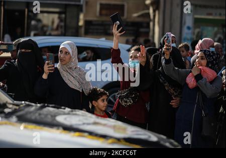 I sostenitori delle Brigate di Saraya al-Quds, l'ala armata del movimento islamico palestinese della Jihad, si riuniscono per guardarli sfilare nelle strade di Gaza il 29 maggio 2021, più di una settimana dopo che un cessate il fuoco ha portato alla fine di 11 giorni di ostilità tra Israele e Hamas. (Foto di Majdi Fathi/NurPhoto) Foto Stock