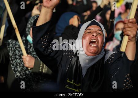 I sostenitori delle Brigate di Saraya al-Quds, l'ala armata del movimento islamico palestinese della Jihad, si riuniscono per guardarli sfilare nelle strade di Gaza il 29 maggio 2021, più di una settimana dopo che un cessate il fuoco ha portato alla fine di 11 giorni di ostilità tra Israele e Hamas. (Foto di Majdi Fathi/NurPhoto) Foto Stock
