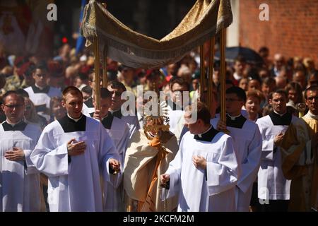 I cattolici celebrano il Corpus Domini partecipando alla Santa Messa e alla processione durante la pandemia del coronavirus. Cracovia, Polonia il 4 giugno 2021. La processione inizia con un sacerdote che porta un mostrania sotto un baldacchino. I fedeli lo seguono cantando inni religiosi, mentre le giovani ragazze vestite con abiti bianchi o tradizionali regionali spargono petali di fiori lungo il percorso. Il Corpus Christi è una festa cattolica mobile che commemora la Transostituzione. (Foto di Beata Zawrzel/NurPhoto) Foto Stock